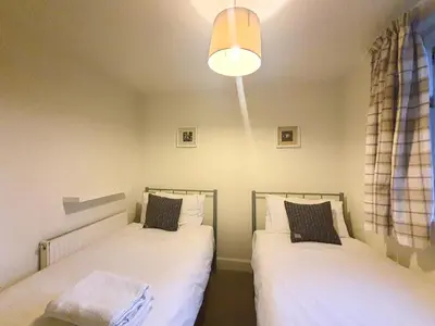 two beds sitting next to each other in a bedroom at Edinburgh 2-Bedroom Cottage with Parking - Ground Floor in Edinburgh