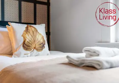 a bed with a pillow with a butterfly on it at Uddingston Apartment by Klass Living in Uddingston