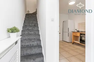 a staircase leading up to a kitchen with a refrigerator at FOUNDRY - 2 Bedrooms, Fully Equipped, Free Parking, WiFi, FAVOURITE for Contractors, Long Stays Welcome, Food, Bars, Shops by Diamond Short Lets in Dunfermline