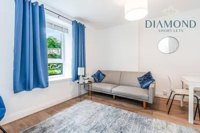 a living room with a couch and a table at FOUNDRY - 2 Bedrooms, Fully Equipped, Free Parking, WiFi, FAVOURITE for Contractors, Long Stays Welcome, Food, Bars, Shops by Diamond Short Lets in Dunfermline