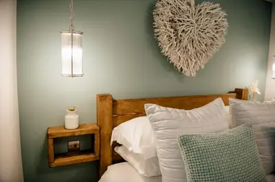 a bedroom with a bed with a heart on the wall at Otterburn House in Rothesay