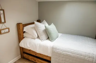 a bedroom with a bed with white sheets and pillows at Otterburn House in Rothesay