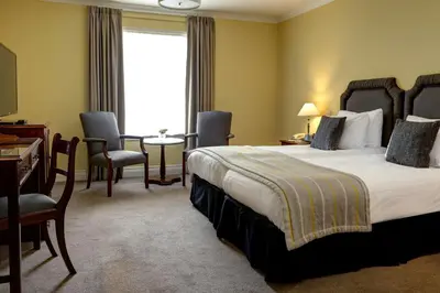 a hotel room with a bed and a table and chairs at Best Western Plus Dunfermline Crossford Keavil House Hotel in Dunfermline