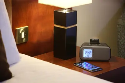 a clock sitting on a table next to a bed at Best Western Plus Dunfermline Crossford Keavil House Hotel in Dunfermline