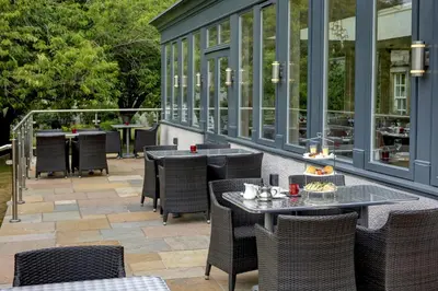 an outdoor patio with tables and chairs and windows at Best Western Plus Dunfermline Crossford Keavil House Hotel in Dunfermline