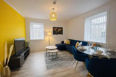 a living room with a blue couch and a table at Stylish 2-Bed Apartment in Greenock - Sleeps 6 in Greenock