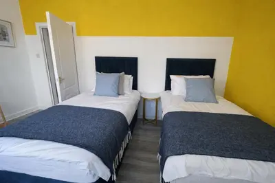 two beds in a room with yellow and white at Stylish 2-Bed Apartment in Greenock - Sleeps 6 in Greenock