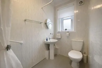 a white bathroom with a toilet and a sink at Stylish 2-Bed Apartment in Greenock - Sleeps 6 in Greenock