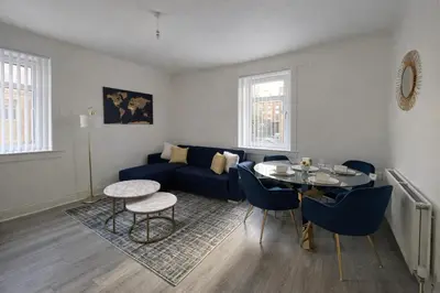 a living room with a blue couch and a table at Stylish 2-Bed Apartment in Greenock - Sleeps 6 in Greenock