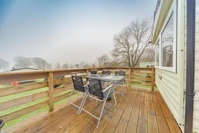 a wooden deck with a table and chairs on it at Newton Stewart-Sleeps 6-Pool-Parking-Pet Friendly in Newton Stewart