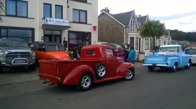 an old red truck parked on the side of a street at Cadillac Kustomz Guest House in Rothesay