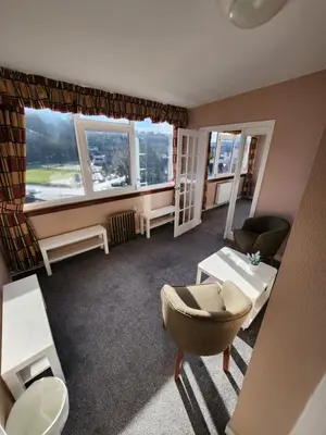a living room with a large window and a chair at King's Knoll Hotel in Oban