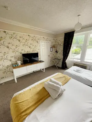 a bedroom with a bed and a tv on a wall at King's Knoll Hotel in Oban