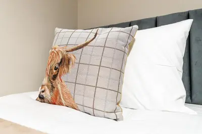 a pillow with a picture of a goat on it at Shaw Apartment in Glasgow