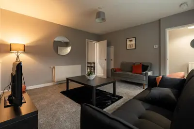 a living room with a couch and a table at The Bowhouse in Grangemouth