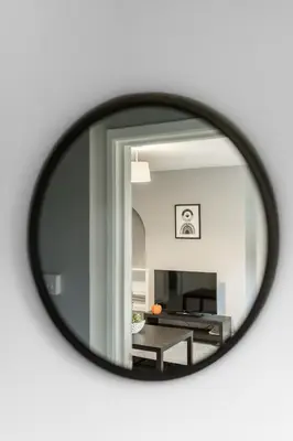 a mirror reflecting a living room with a table at The Bowhouse in Grangemouth