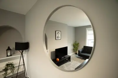 a living room with a mirror on the wall at The Bowhouse in Grangemouth