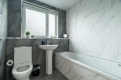 a bathroom with a sink and a toilet and a bath tub at The Bowhouse in Grangemouth