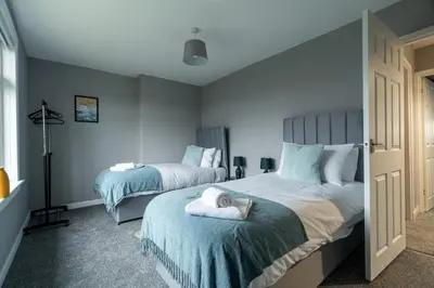 a bedroom with two beds with blue and white at The Bowhouse in Grangemouth