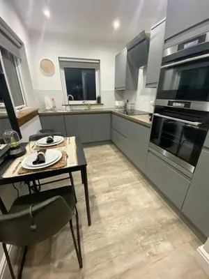 a large kitchen with a table and a stove at Mackie lodge in Luss