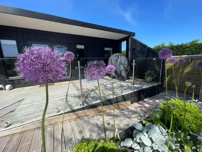 a garden with purple flowers on a wooden deck at Mackie lodge in Luss