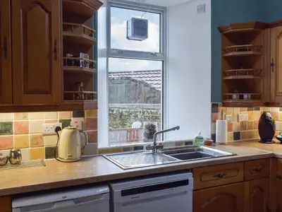 a kitchen with a sink and a window at Wayside Cottage in Dunoon