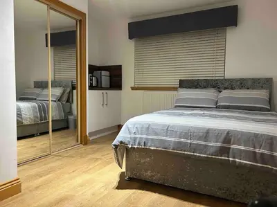 a bedroom with a large bed and a mirror at 101 Scotia Rooms in South Cobbinshaw