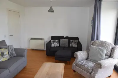 a living room with a couch and a chair at The Barn at Drumachro in Isle of Gigha