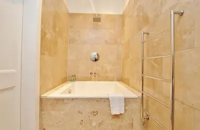 a bathroom with a tub and a shower at Elegant 3-Bedroom Ramsay Garden Apartment in Edinburgh City Centre in Edinburgh