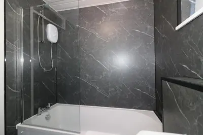 a bathroom with a white bath tub and a sink at Signature - Glen Garry House in East Kilbride