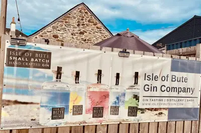 a sign for a bottle of blue gin company on a fence at Beautiful spacious old schoolhouse with stunning sea views and beach nearby in Port Bannatyne