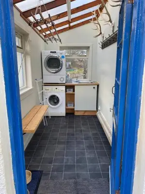 a laundry room with a washer and dryer in a house at Alltcreich in Craignure