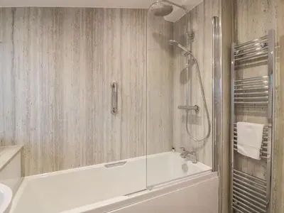 a bathroom with a white tub and a shower at Thorneydyke Cottage in Stirling