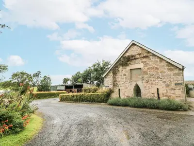 an old stone barn on a gravel road at Thorneydyke Cottage in Stirling