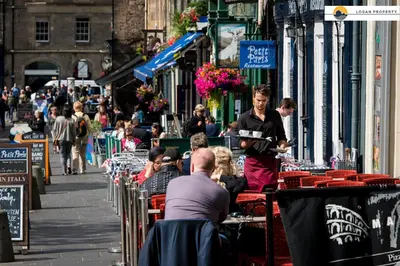 a woman standing on a street with a tray of food at Lady Wynd - 1 bed apartment in Edinburgh
