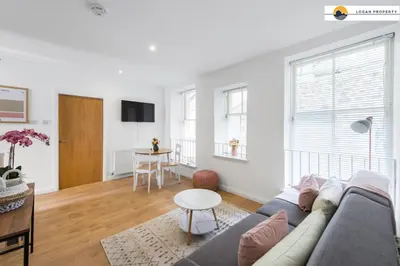 a living room with a couch and a table at Lady Wynd - 1 bed apartment in Edinburgh
