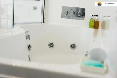 a bathroom with a white tub and a sink at Lady Wynd - 1 bed apartment in Edinburgh