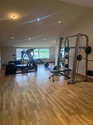 a gym with several treadmills and machines in a room at Langside apartments in Newhouse