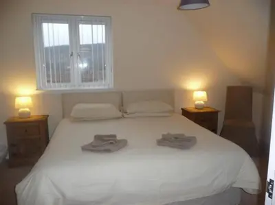 a bedroom with a white bed with two towels on it at Glenview Salen in Salen