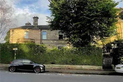 a black car parked in front of a house at Immaculate 3 Bed Apartment with Private Entrance in Inverleith in Edinburgh
