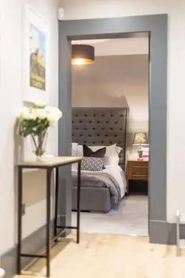 a bedroom with a bed and a table with flowers at Immaculate 3 Bed Apartment with Private Entrance in Inverleith in Edinburgh