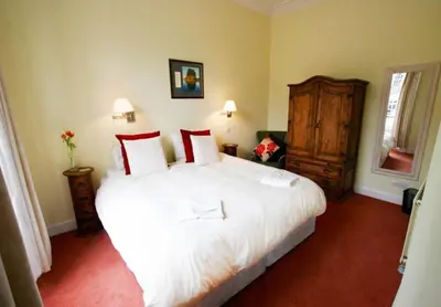a bedroom with a large white bed with red pillows at Edlets - Frederick Street Apartment in Edinburgh