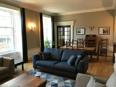a living room with a blue couch and a table at Edlets - Frederick Street Apartment in Edinburgh