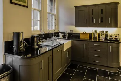 a kitchen with gray cabinets and a black counter top at Edlets - Frederick Street Apartment in Edinburgh
