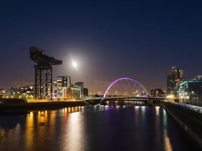 a bridge over a river in a city at night at Glasgow, Finnieston Luxury 2 Bed with parking, e-check in, hi-fi in Glasgow