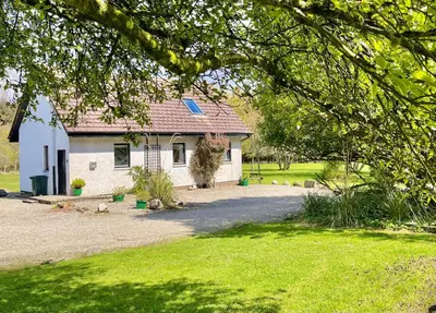 a small white house in a yard at Heronlea Cottage in Dunoon