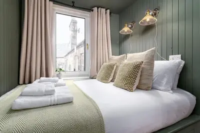 a bedroom with a large white bed with a window at The Stylish 3-Bedroom Maisonette Retreat in Stirling