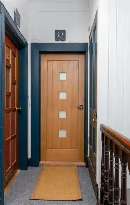 a hallway with a wooden door in a building at The Stylish 3-Bedroom Maisonette Retreat in Stirling