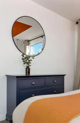 a mirror on top of a dresser in a bedroom at The Stylish 3-Bedroom Maisonette Retreat in Stirling