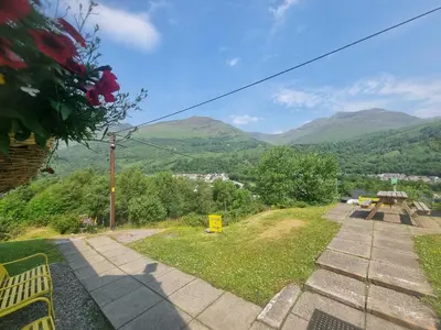 a view of the mountains from a park with benches at West Highland Lodge in Kinlochleven